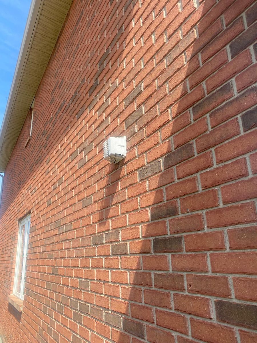An exterior vent cap installed through a brick wall